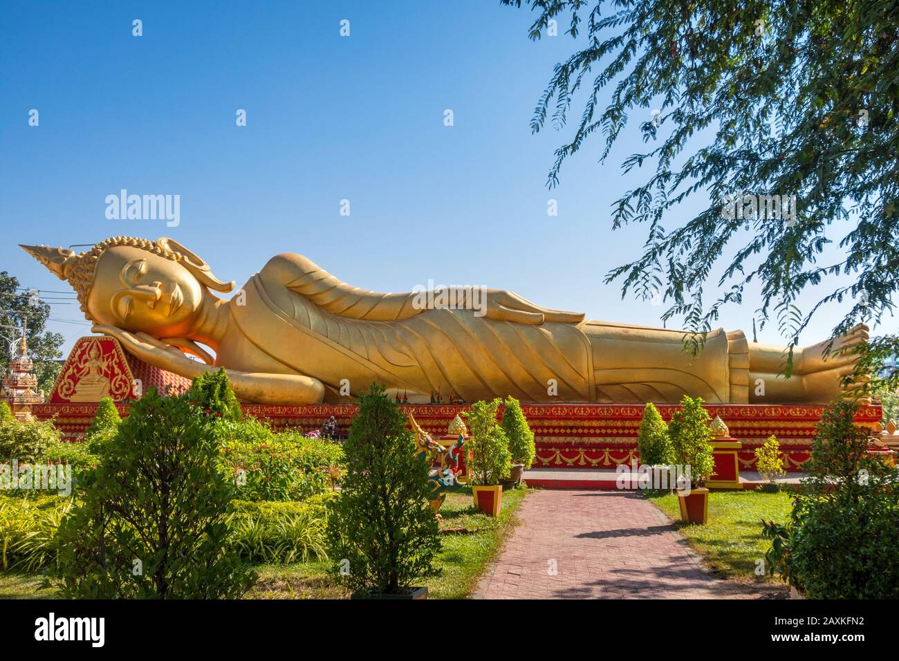 Golden Reclining Buddha in gardens at Wat Pha That Luang Vientiane Laos Stock Photo