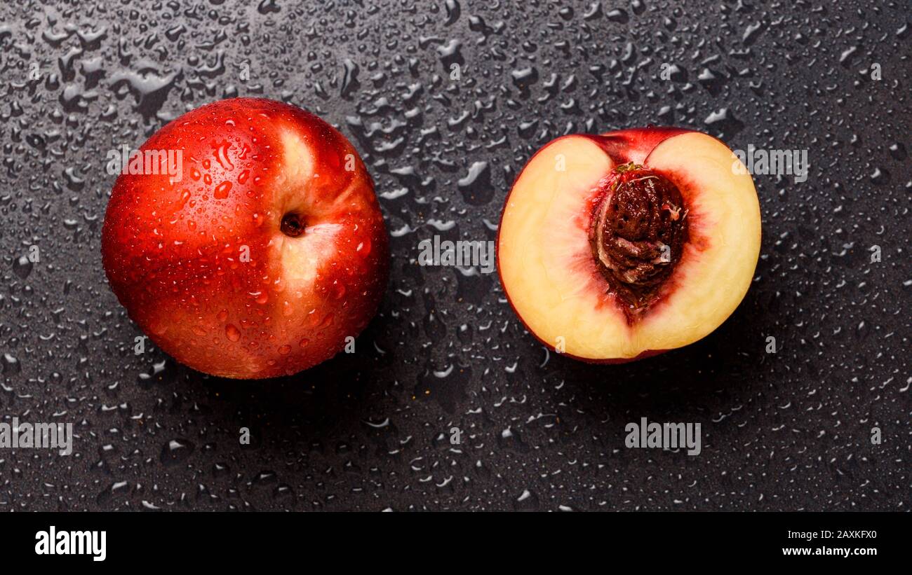 Nectarine fruit isolated on wet black background Stock Photo