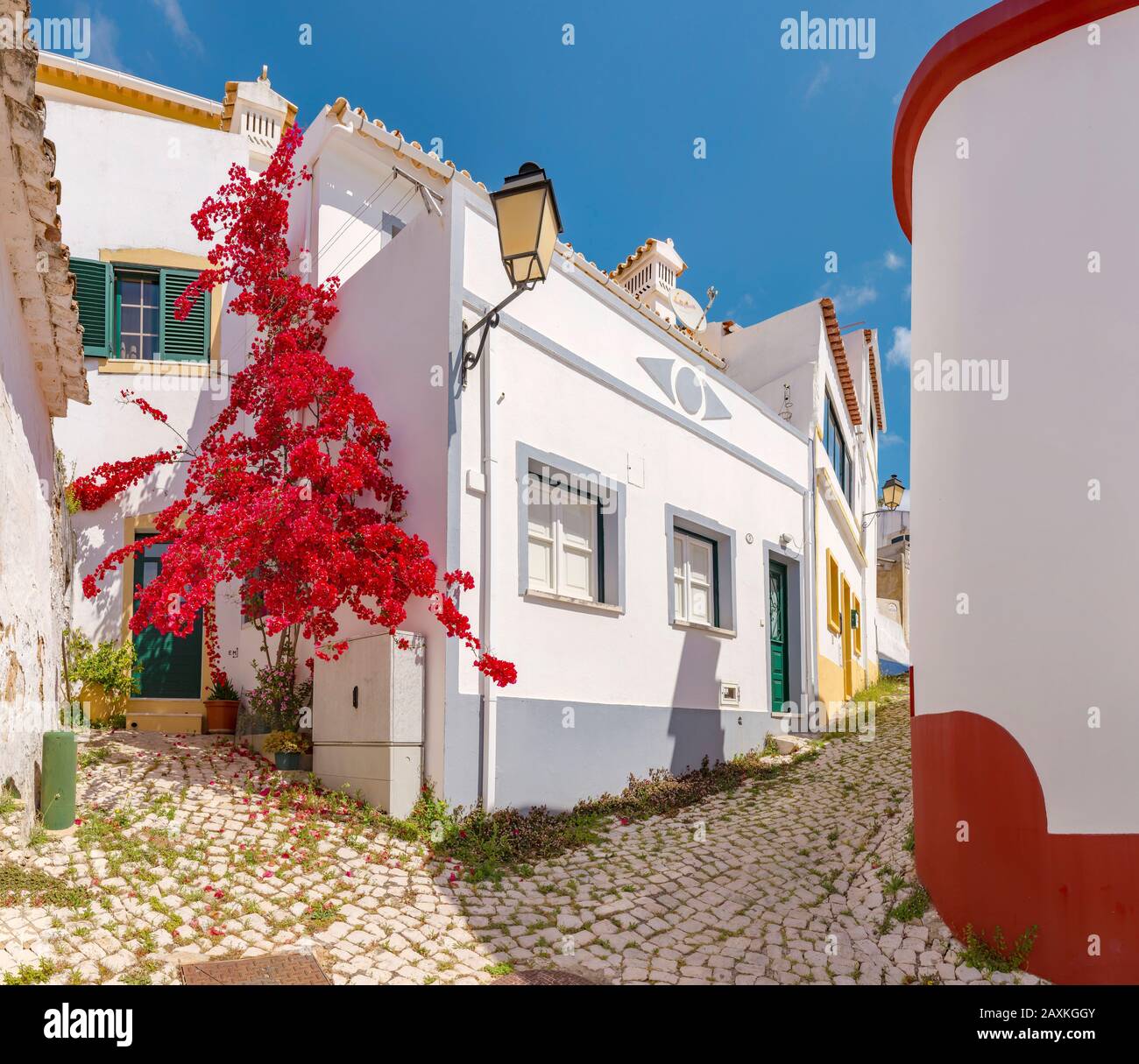 Typical portugese street with a red bougainvillaea, Alte,   Portugal, Stock Photo
