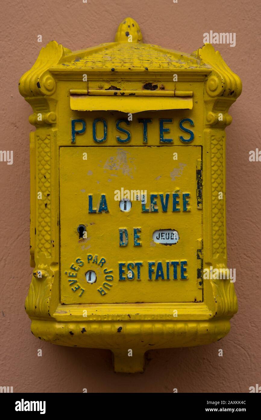 Old yellow french letterbox on a wall Stock Photo