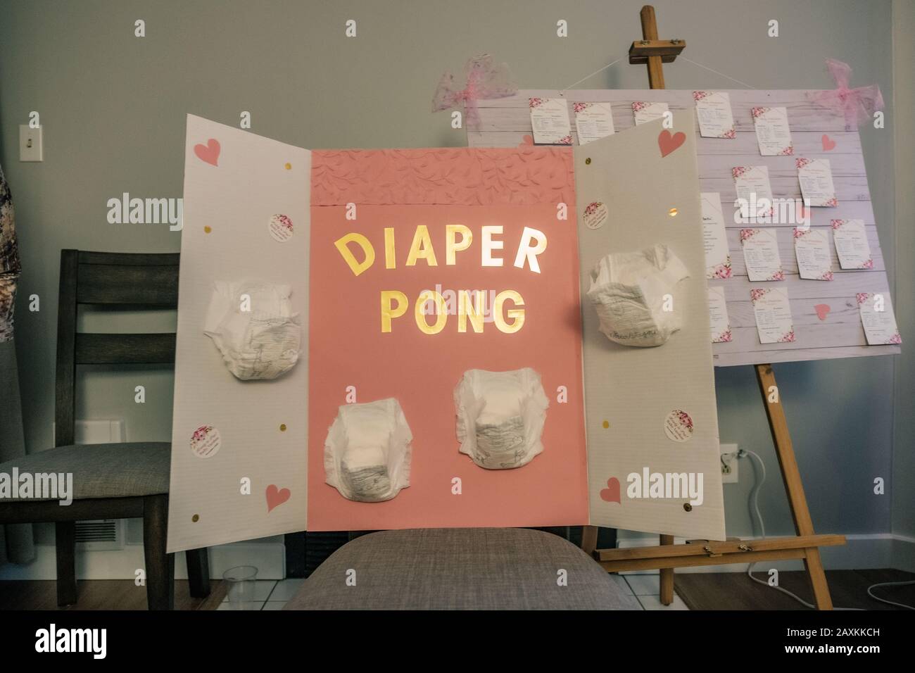 Baby shower game set up of diaper pong with four diapers on a pink and  white board Stock Photo - Alamy