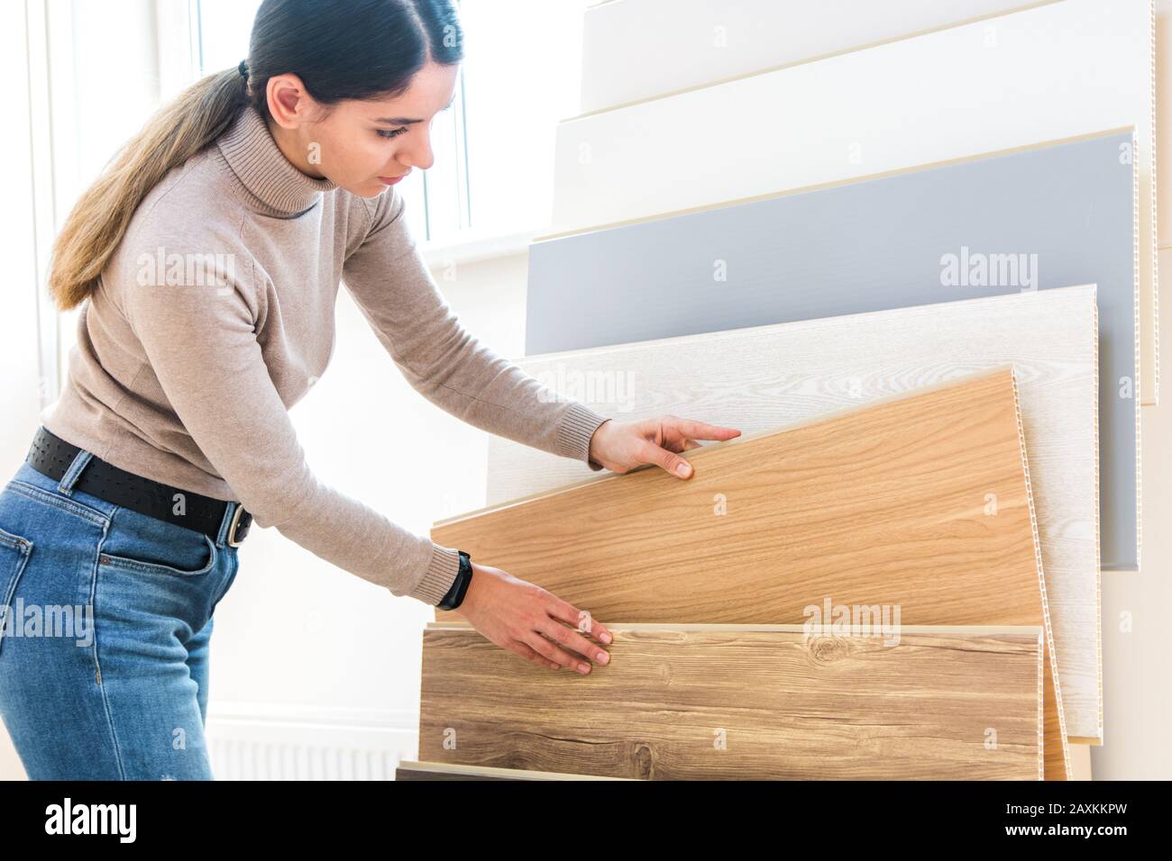 home repair. portrait of woman choosing wood laminated flooring in shop Stock Photo