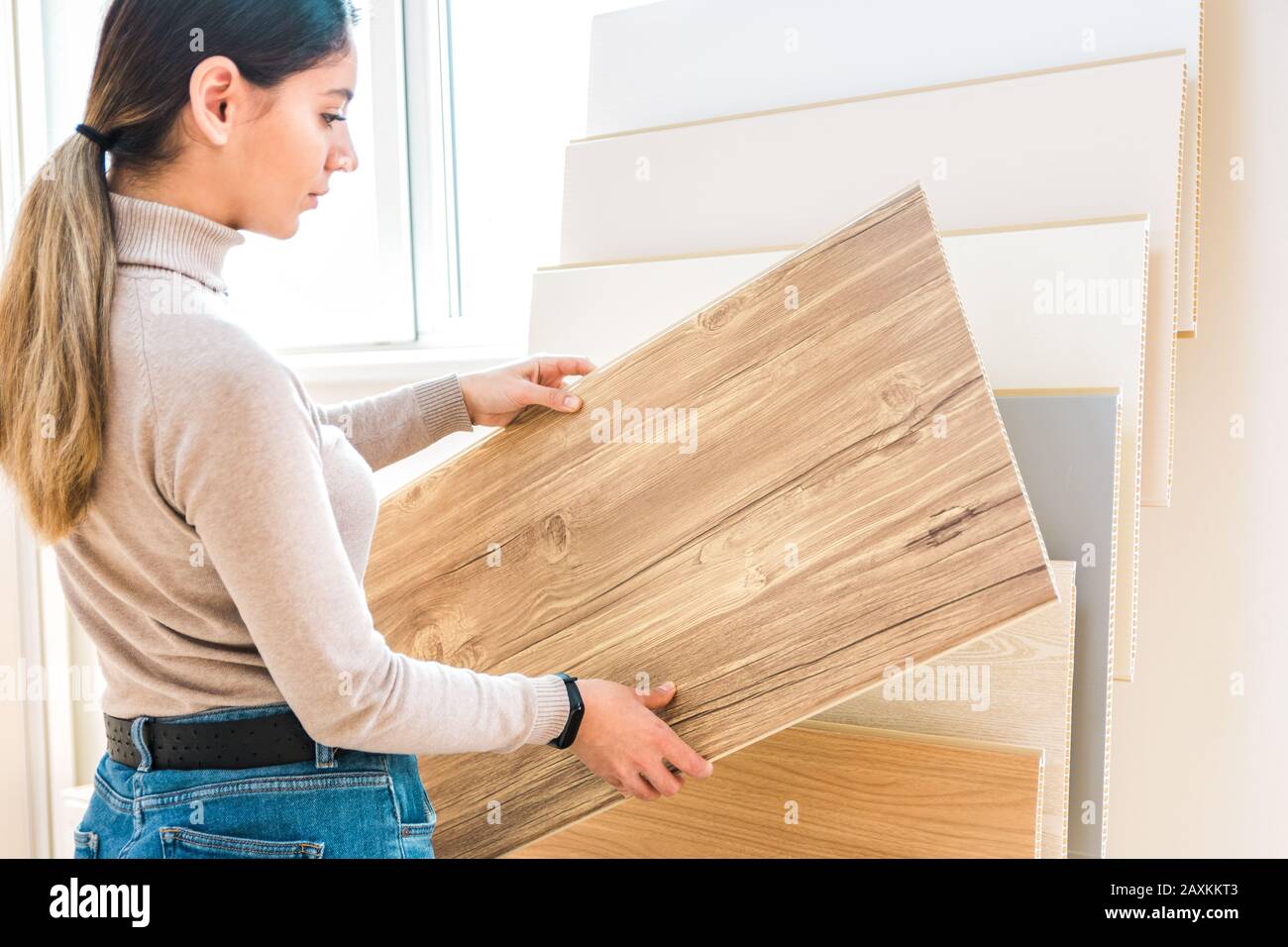 home repair. portrait of woman choosing wood laminated flooring in shop Stock Photo