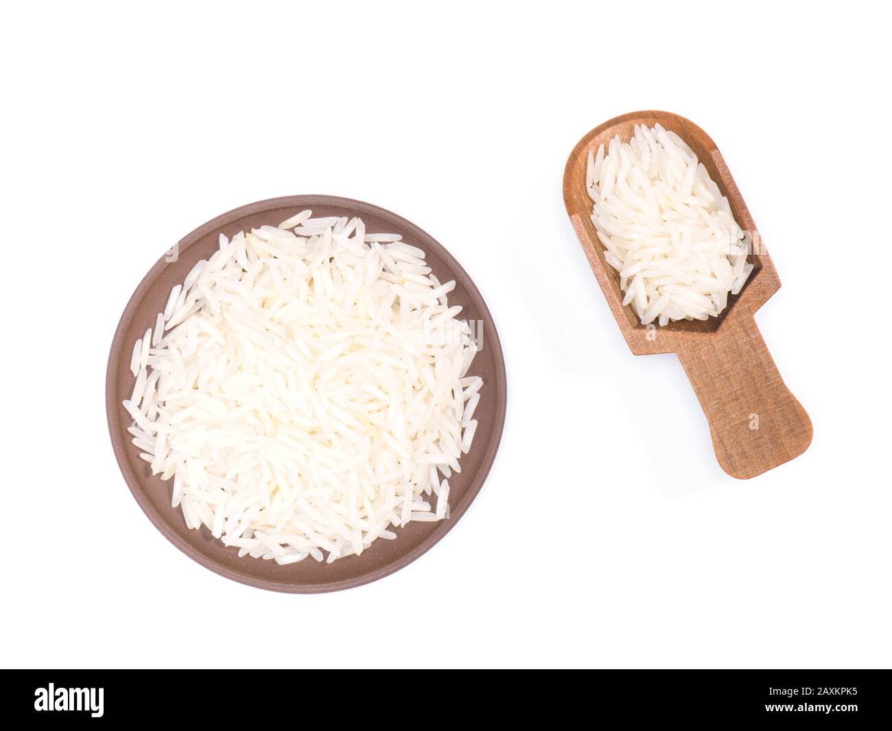 Indian long grain Basmati rice in clay plate and wooden scoop isolated on white. Indian cuisine
