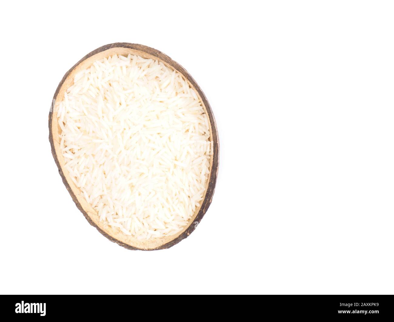 Indian long grain Basmati rice in half coconut shell isolated on white. Indian cuisine, ayurveda, naturopathy concept Stock Photo
