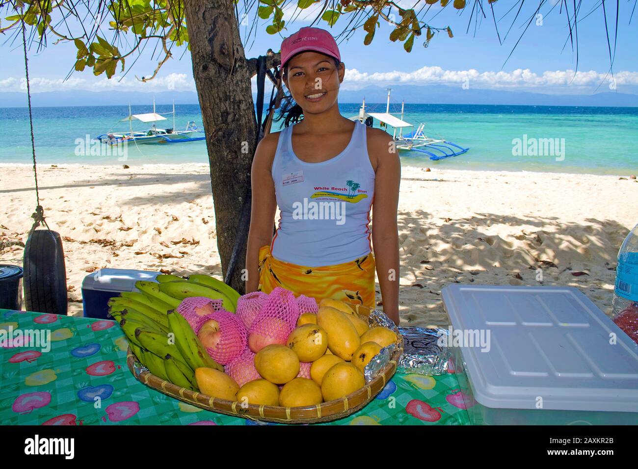 Local girl offers tropical fruits, mango, bananas, beach on Cebu, Philippines Stock Photo