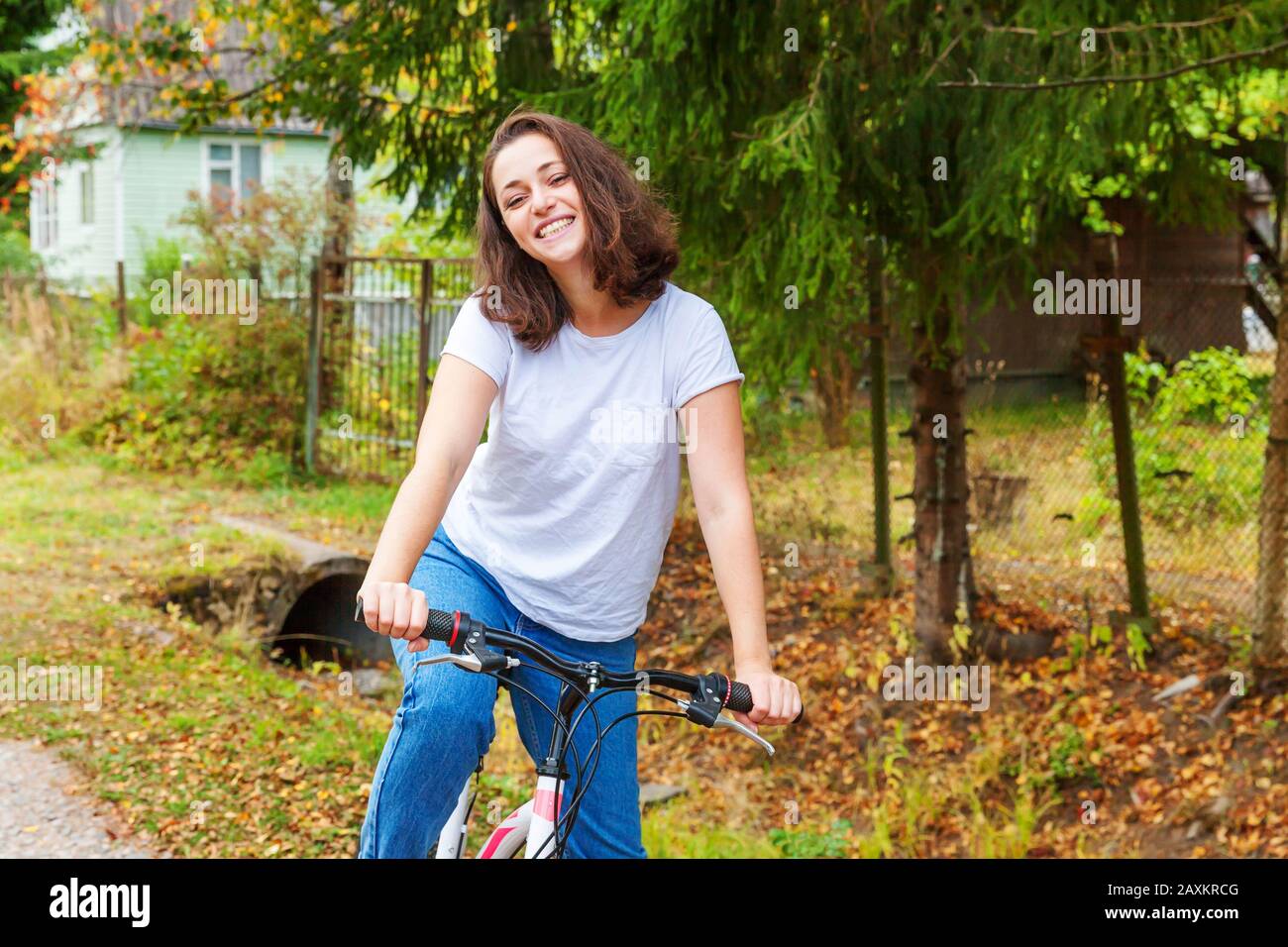 Young woman riding bicycle in summer city park outdoors. Active people. Hipster girl relax and rider bike. Cycling to work at summer day. Bicycle and ecology lifestyle concept Stock Photo