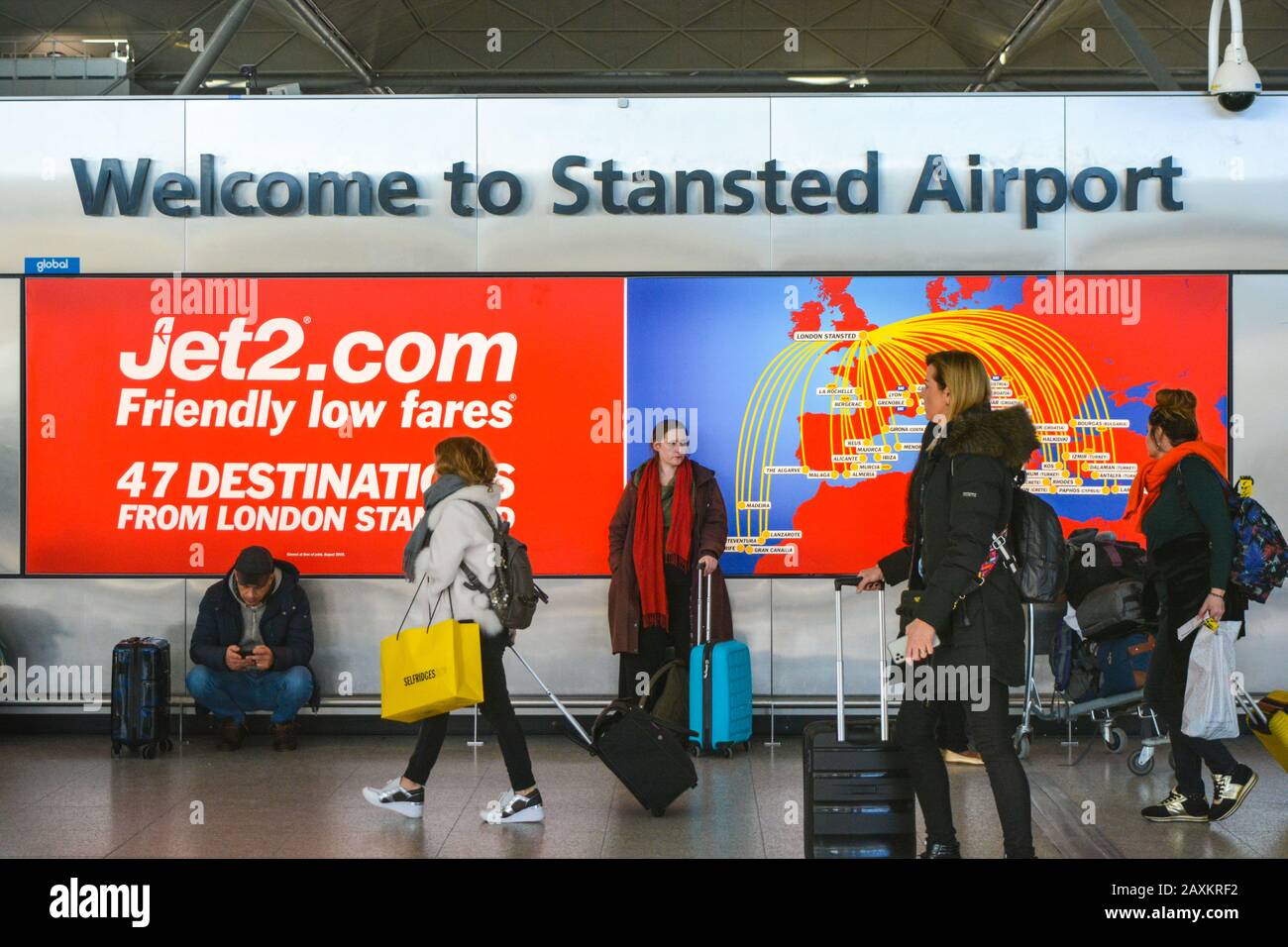 London Stansted Airport STN, United Kingdom UK, 01/18/20 - Entrance of the International Airport. Blurred walking passengers with trolleys and shoppin Stock Photo