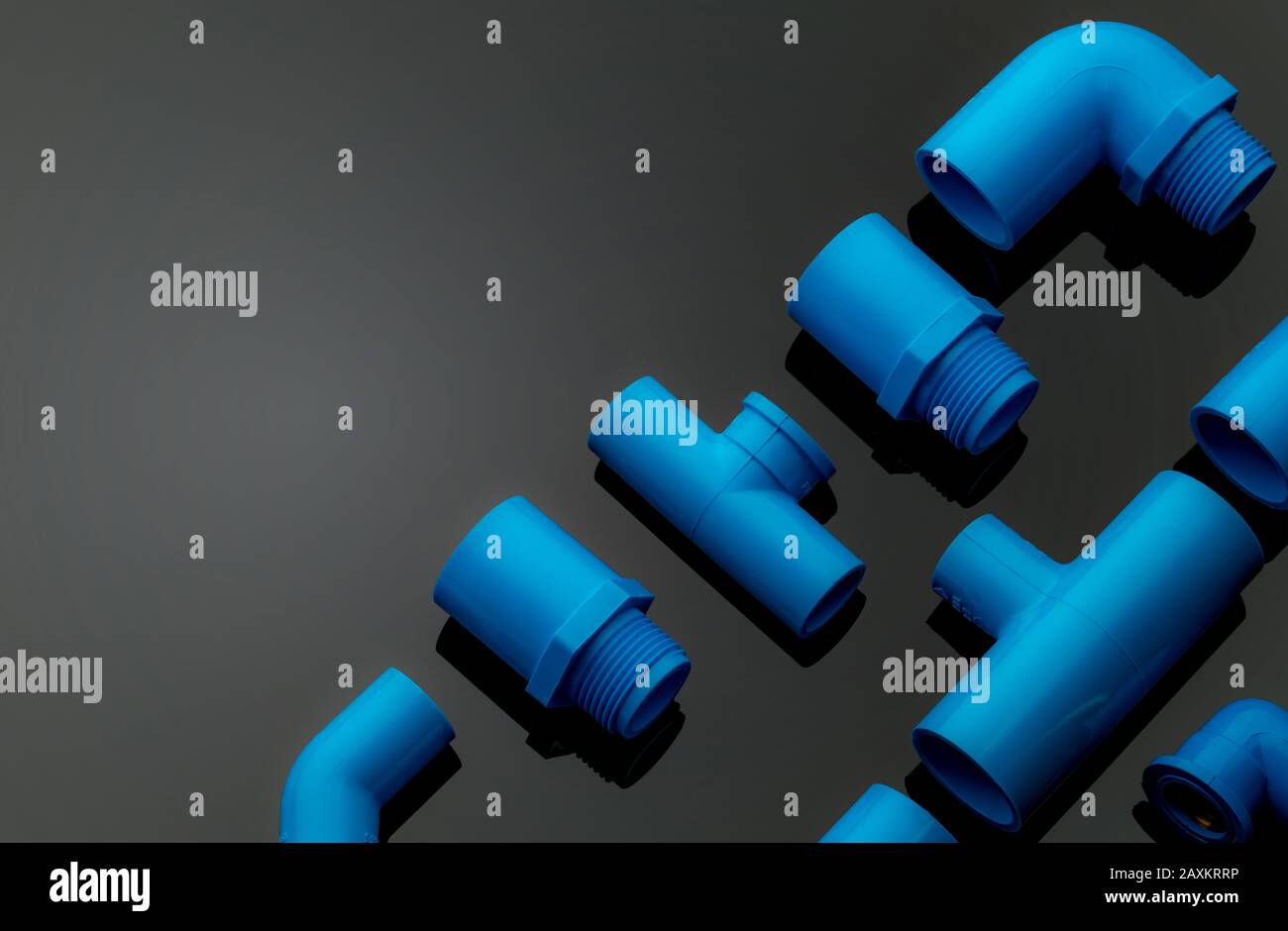 Set of blue PVC pipe fittings isolated on dark background. Blue