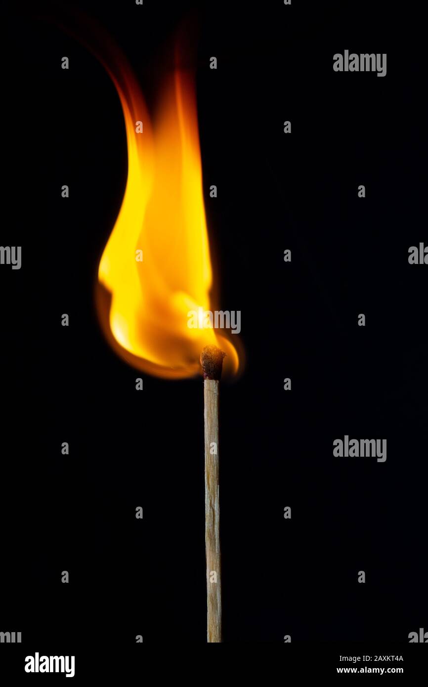 Flame on the matchstick over dark background Stock Photo