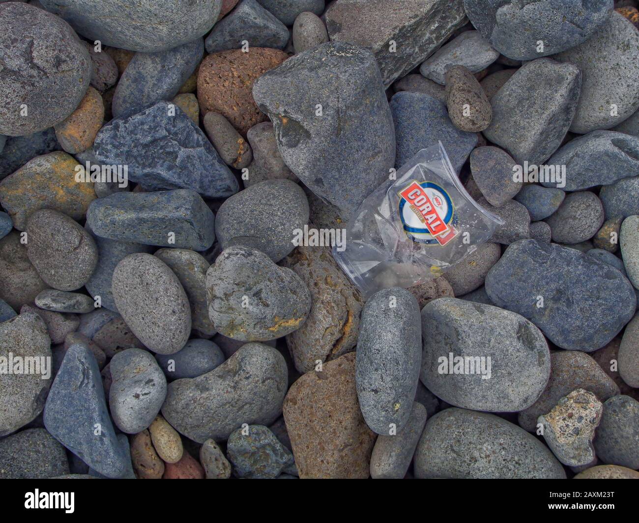 Discarded flotsam on a pebble beach example of environmental pollution