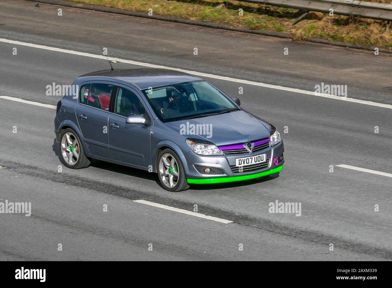 2007 silver Vauxhall Astra Elite with green bumper; UK Vehicular traffic, transport, modern saloon cars, on the M61 motorway, Manchester, UK Stock Photo
