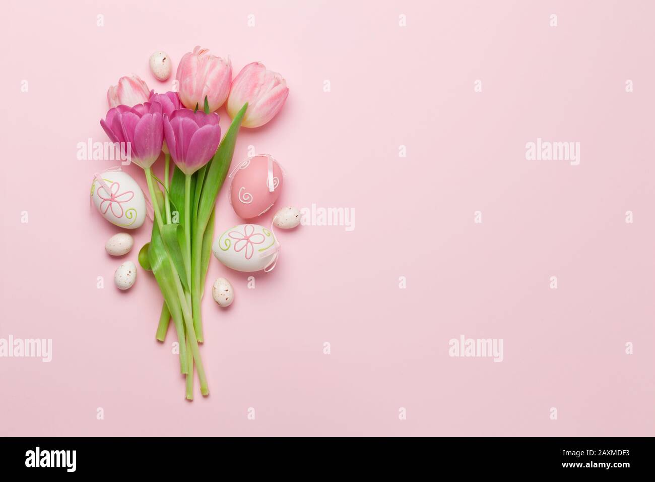 Easter greeting card with easter eggs and tulip flowers over pink ...