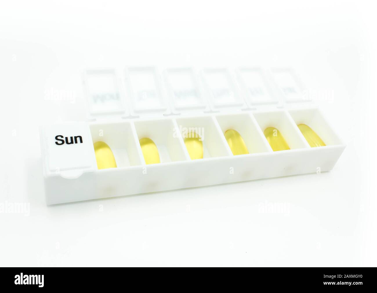 Download Close Up Of Weekly Medicine Box Containing Yellow Capsules White Background Stock Photo Alamy PSD Mockup Templates