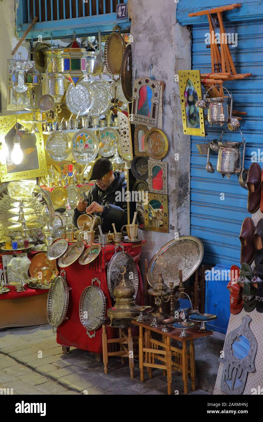 TUNIS, TUNISIA - DECEMBER 31, 2019: Brass and copper craftsman at work in the souk inside the medina Stock Photo