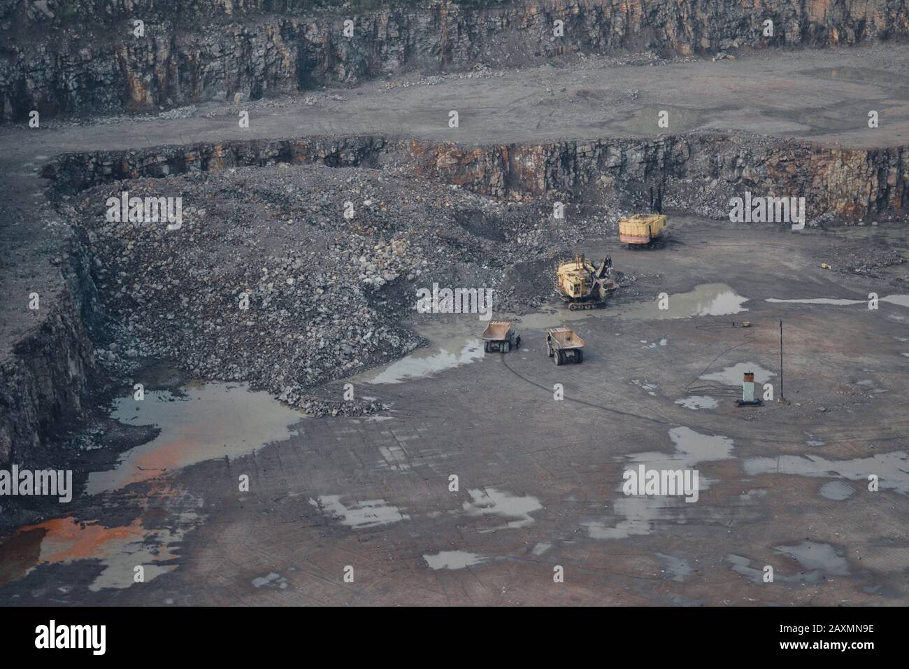 Yellow cars in a large quarry mining granite Stock Photo