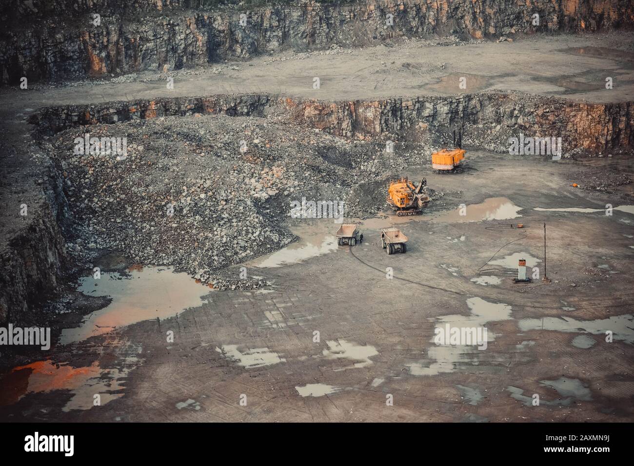 Yellow cars in a large quarry mining granite Stock Photo