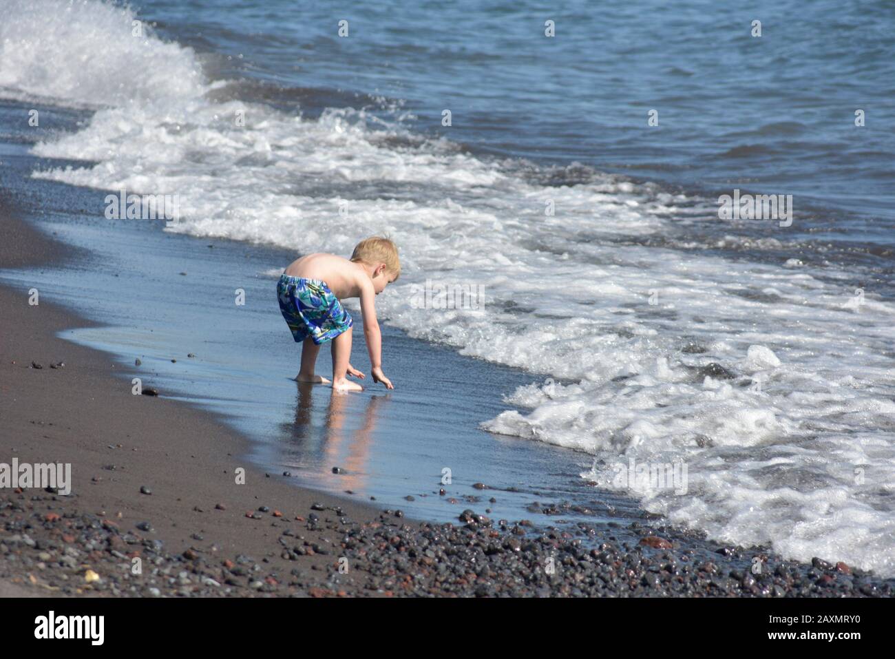 little boy playing at the shore of a lake Stock Photo