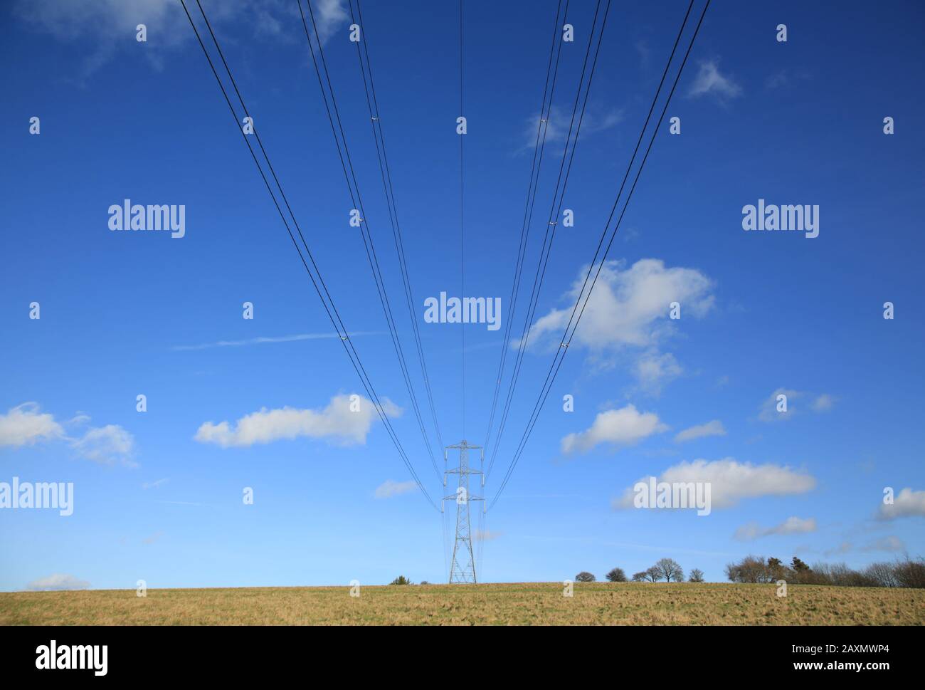 Electricity pylon and cables against a blue sky Stock Photo - Alamy
