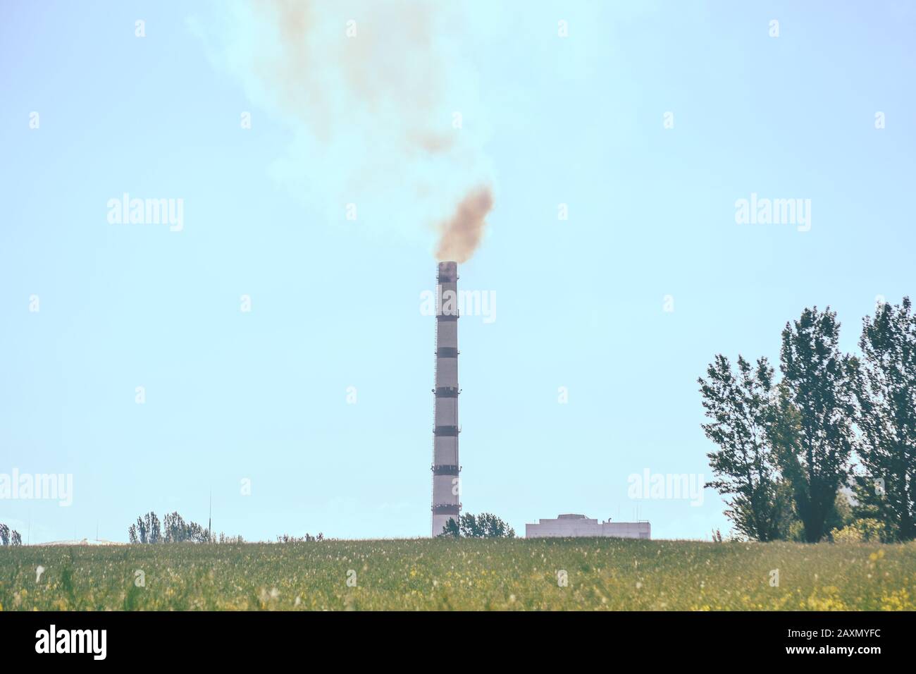 Pipe factory smoke in the field with clear sky. Stock Photo