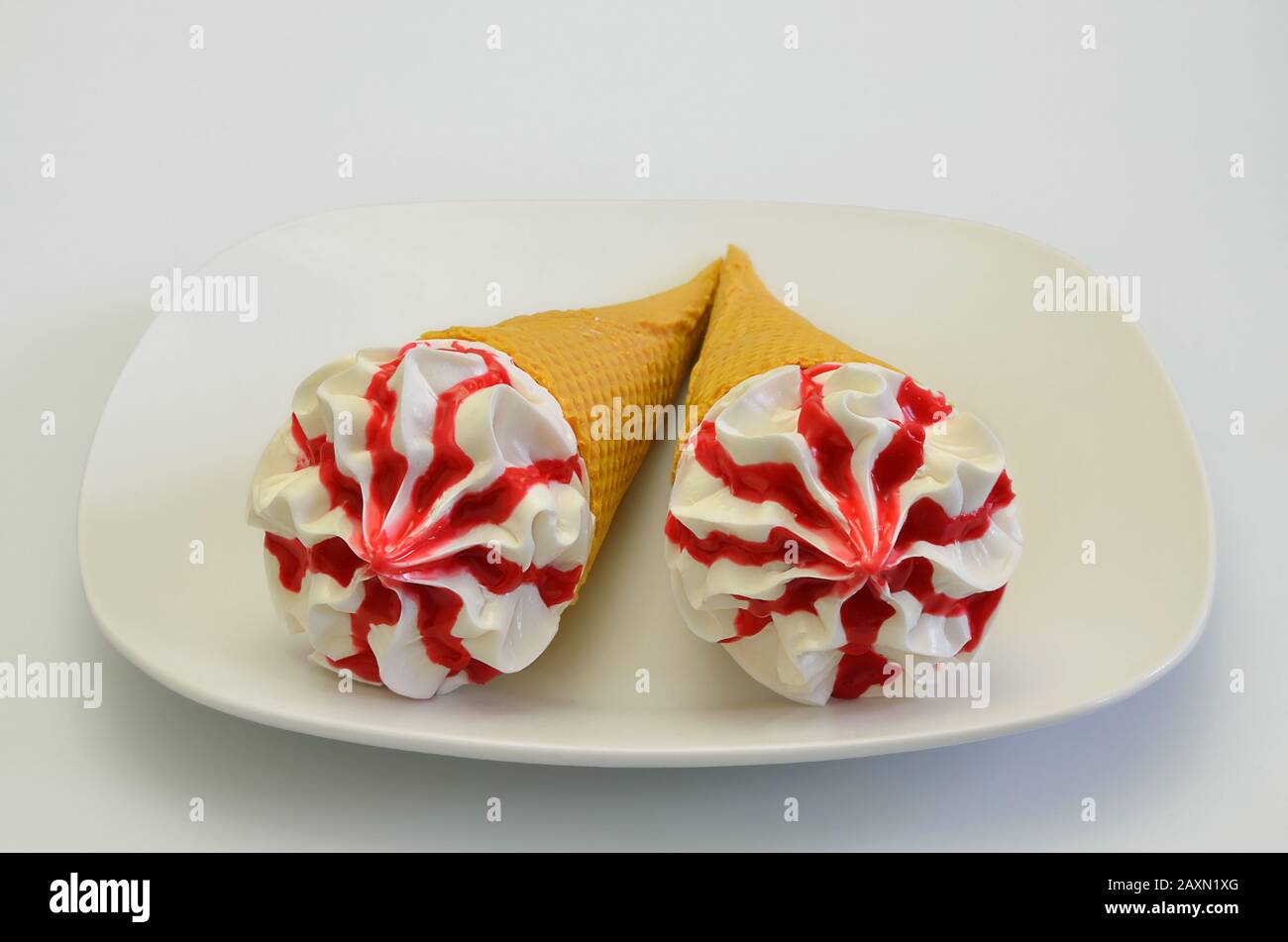 Two Strawberry ice cream cones on white Plate, isolated on white Background, extreme close up Stock Photo