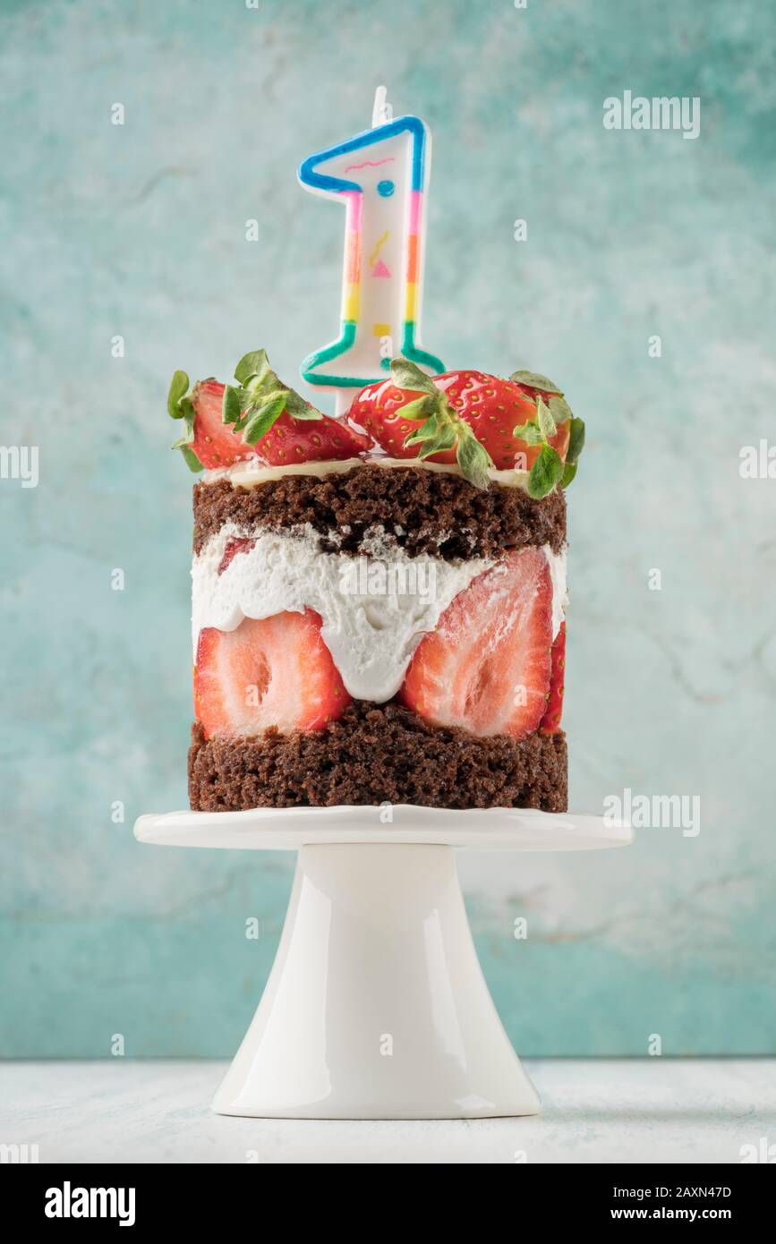 a strawberry cake with number one shaped candle for birthday Stock Photo