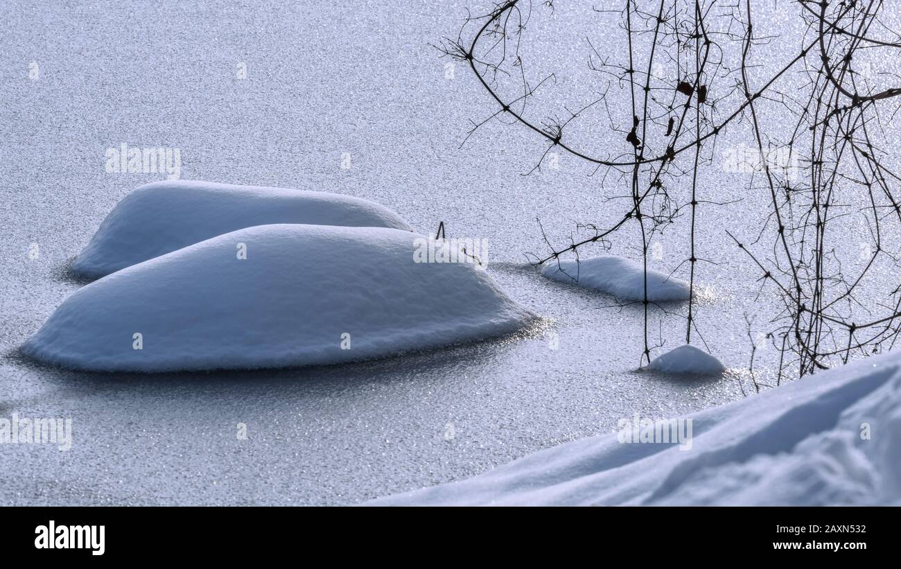 Snow hump on a frozen lake surface, beautiful winter landscape Stock Photo