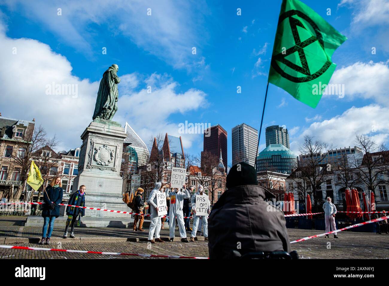 An XR activist holding a flag with the XR logo during the protest.While the Dutch government has a debate about CETA, free trade agreement, the activist group Extinction Rebellion Nederland carried out an action outside of the Houses of Parliament to make a call to stop the CETA agreement. Over 70 organizations worldwide have signed an open letter to call upon the Dutch government to vote against CETA. Stock Photo