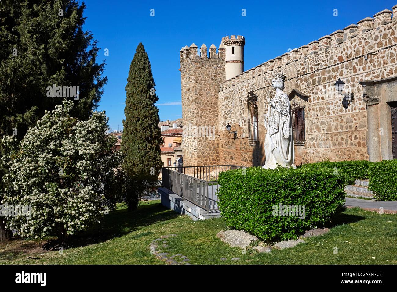 Castle walls and statue of 'Isabella 1 of Castile' with trees and blue skies Stock Photo