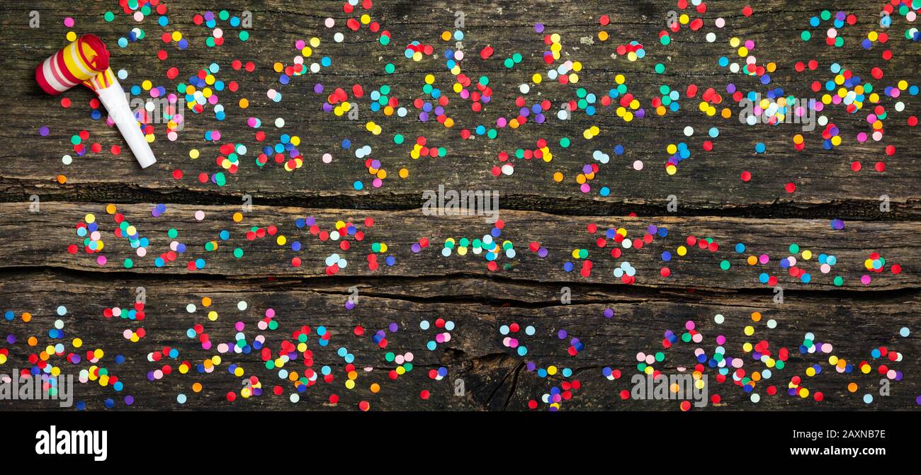 Coloured confetti on wooden, party horn Stock Photo