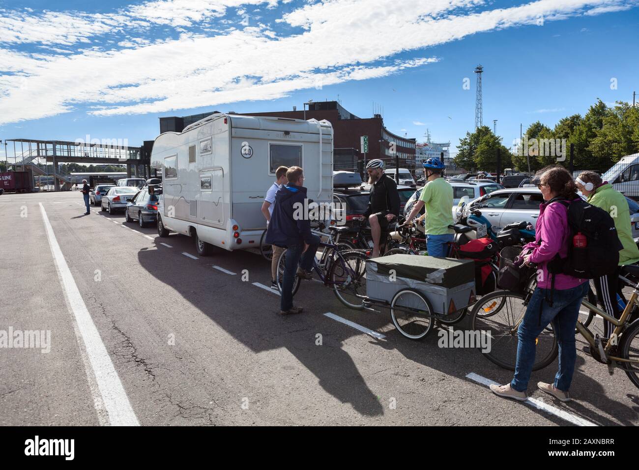 HELSINKI, FINLAND-CIRCA-JUN, 2018: Drivers and cyclists stand in line for embarkation in  passenger ship terminal of Helsinki seaport. Area for all ki Stock Photo