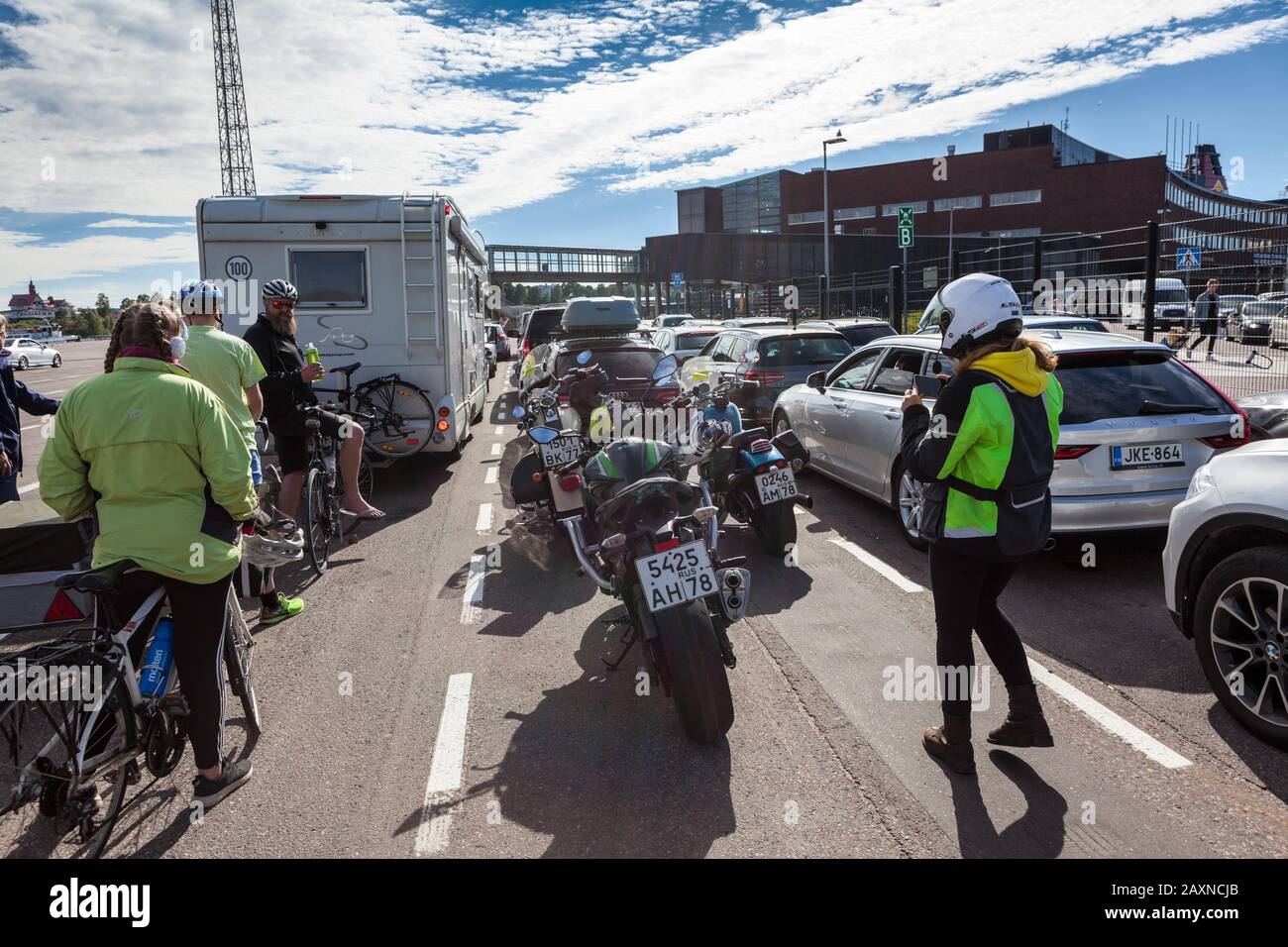 HELSINKI, FINLAND-CIRCA-JUN, 2018: Drivers, motorcyclists and cyclists wait embarkation in  passenger ship terminal of Helsinki seaport. Area for all Stock Photo
