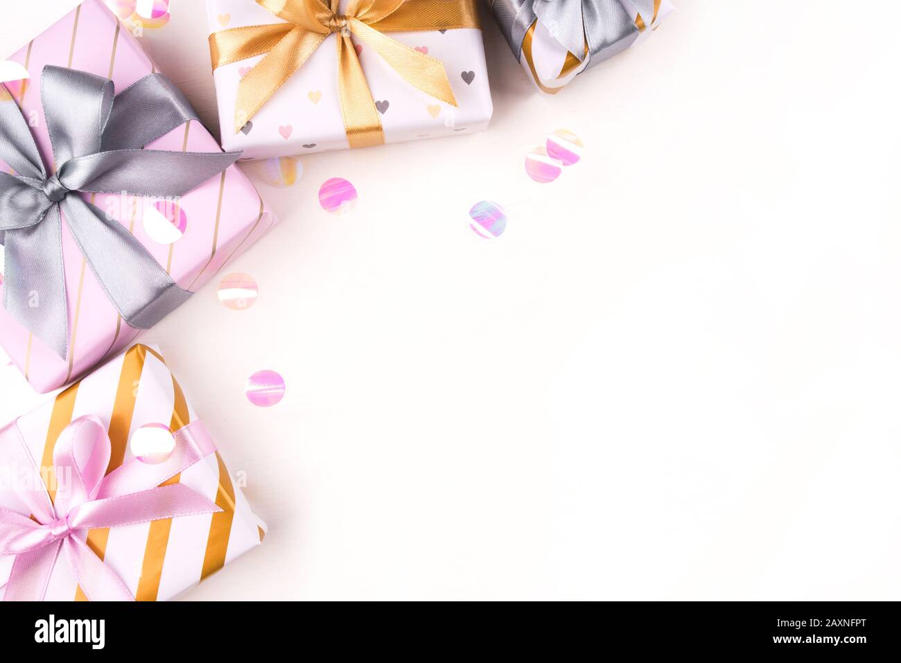 Several gift boxes with bows and confetti on a white background. Stock Photo