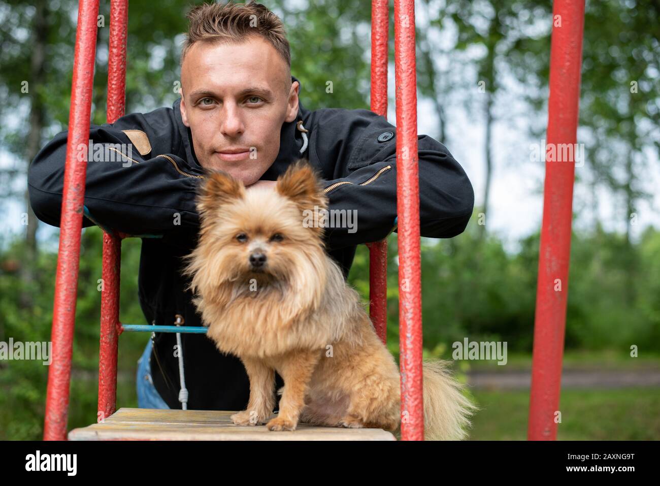 A man with a little dog on a swing. Stock Photo