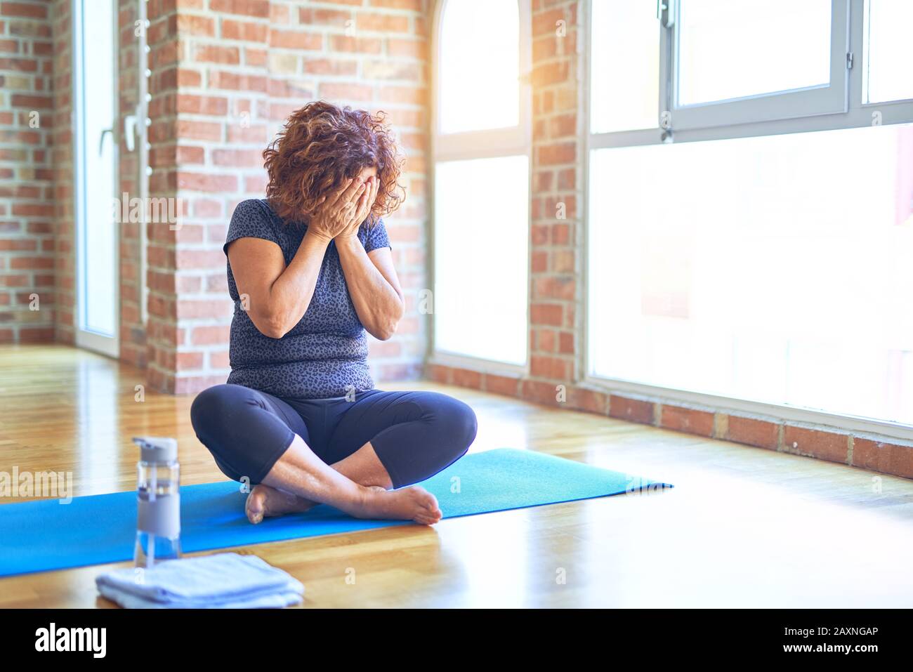 Middle age beautiful sportswoman wearing sportswear sitting on mat  practicing yoga at home with sad expression covering face with hands while  crying Stock Photo - Alamy