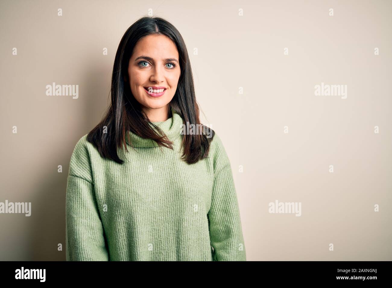 Young brunette woman with blue eyes wearing turtleneck sweater over ...