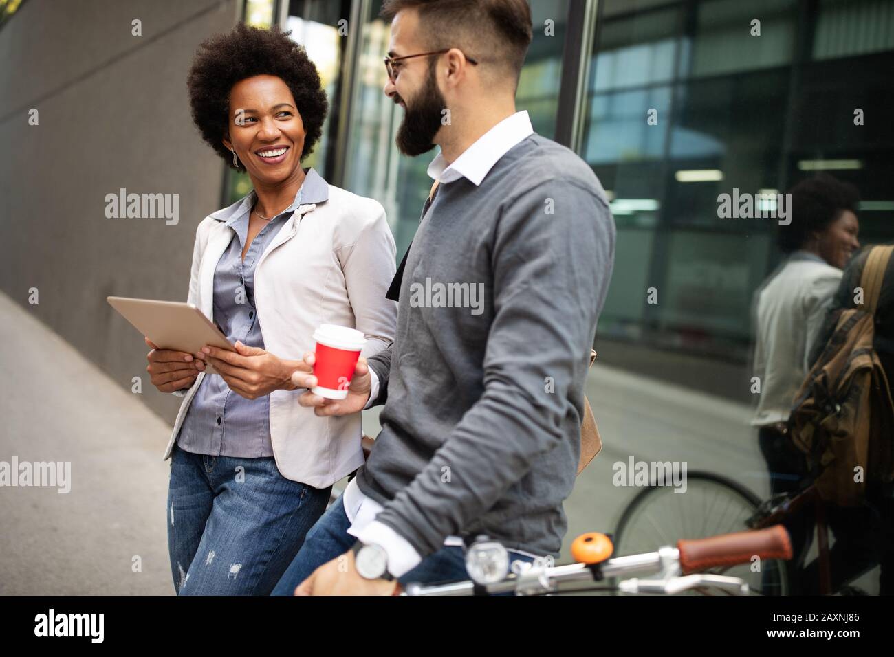 View at young business people talking and smiling outdoors Stock Photo ...