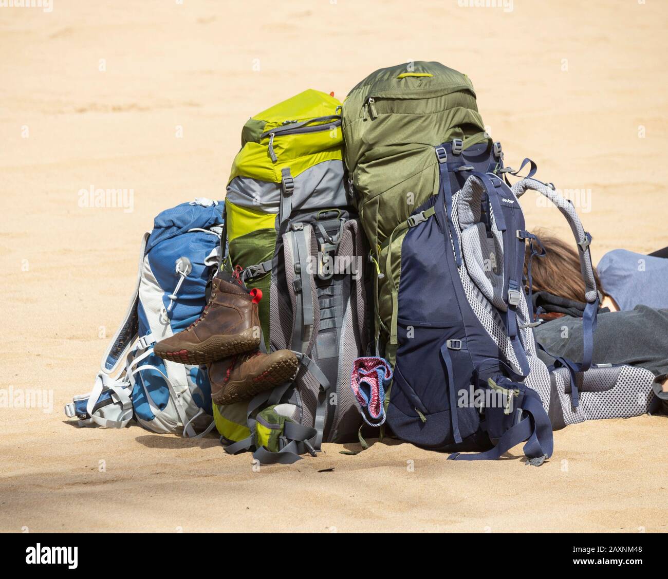 Two young people with large rucksacks resting on beach Stock Photo - Alamy