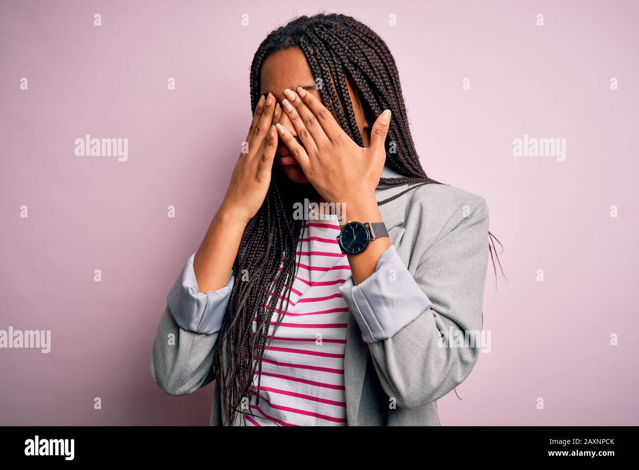 Young african american business woman standing over pink isolated background rubbing eyes for fatigue and headache, sleepy and tired expression. Visio Stock Photo
