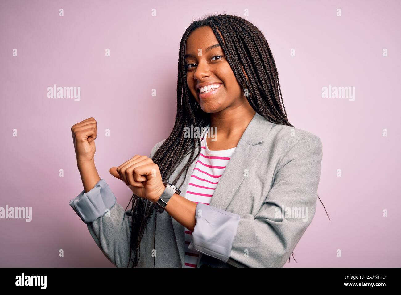 Young african american business woman standing over pink isolated ...