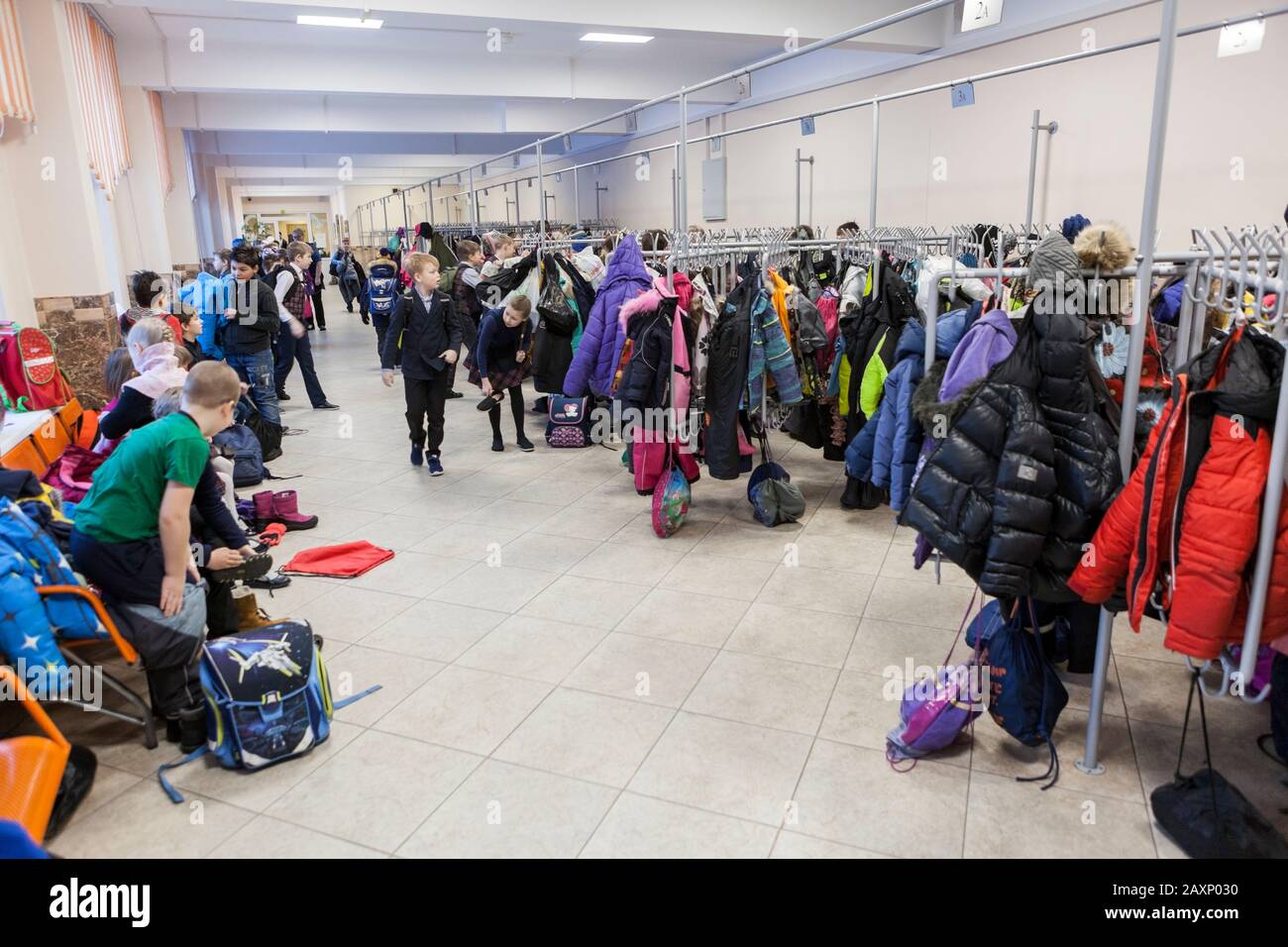 ST. PETERSBURG, RUSSIA-CIRCA MAR, 2019: Crowd of schoolchildren takes off jackets in wardrobe before first lesson. The academic day beginning is in Ru Stock Photo