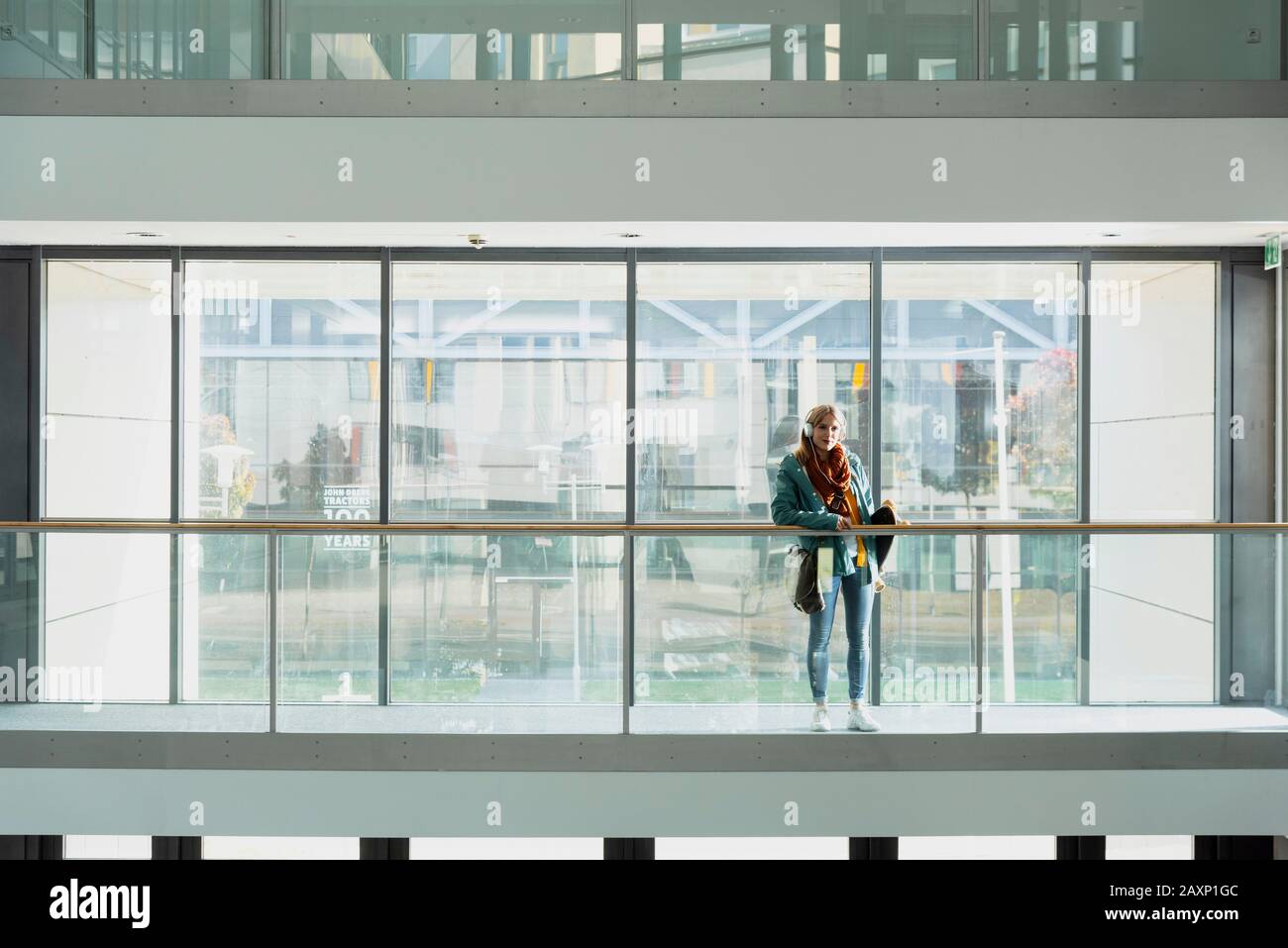 Young woman with skateboard in modern office building Stock Photo