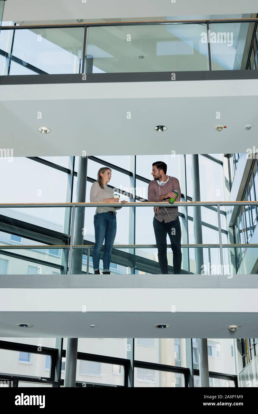 Young woman and young man in modern office building make break Stock Photo
