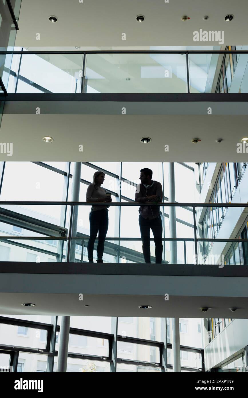 Young woman and young man in modern office building make break Stock Photo