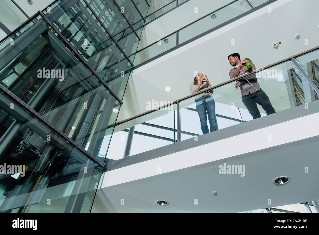 Young woman and young man in modern office building make break Stock Photo