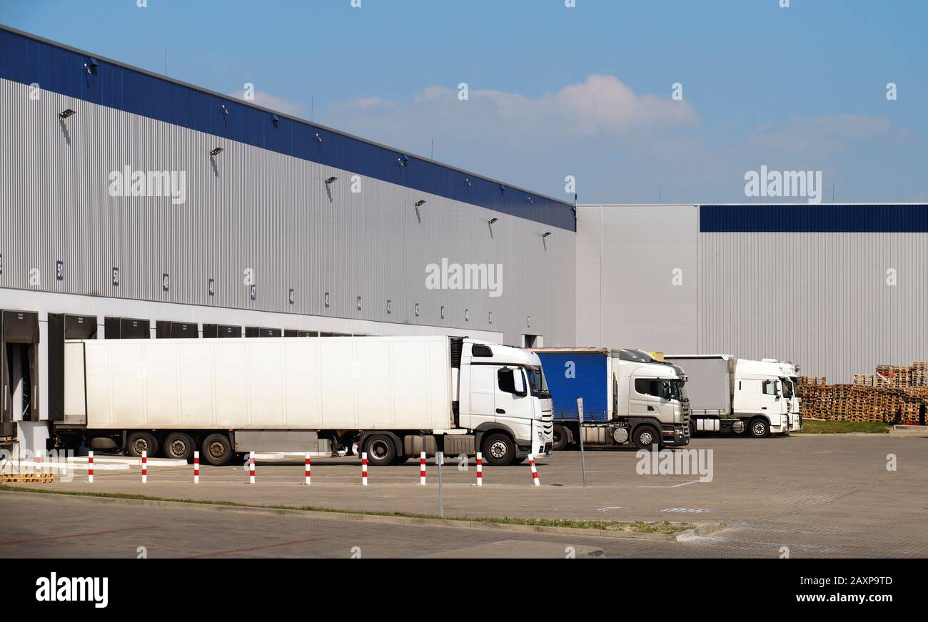 Loading and unloading of goods onto trucks. Distribution centre. Stock Photo