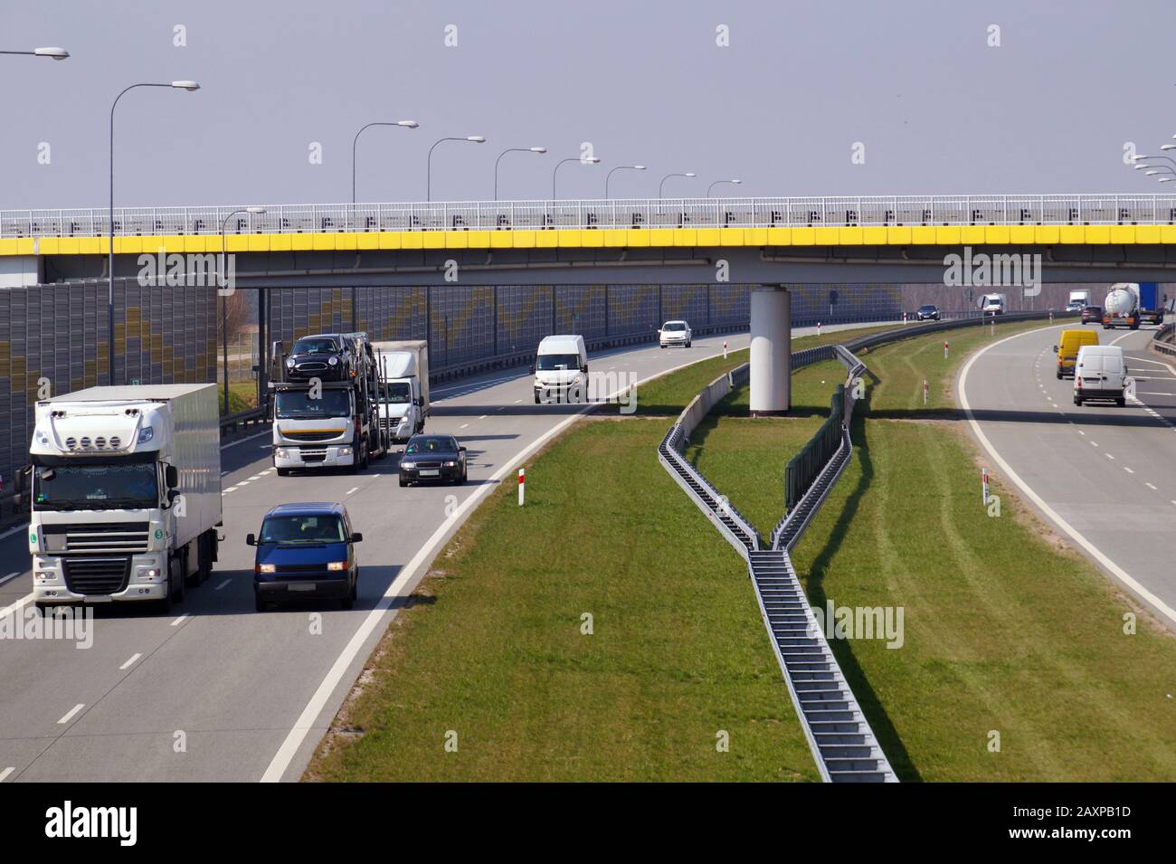 Various cars moving on the highway. In the distance, a view of a road