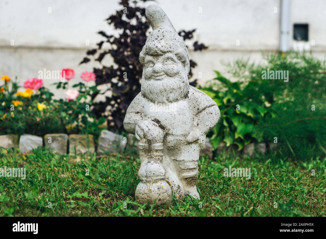 Small dwarf statue in backyard Stock Photo