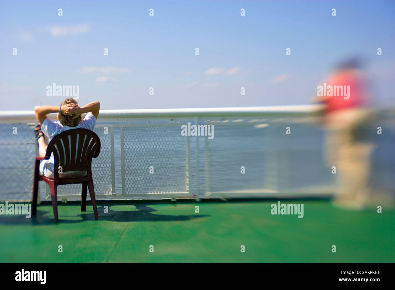 A man relaxing in a plastic deck chair on board a ferry in Long Island sound, Connecticut USA Stock Photo