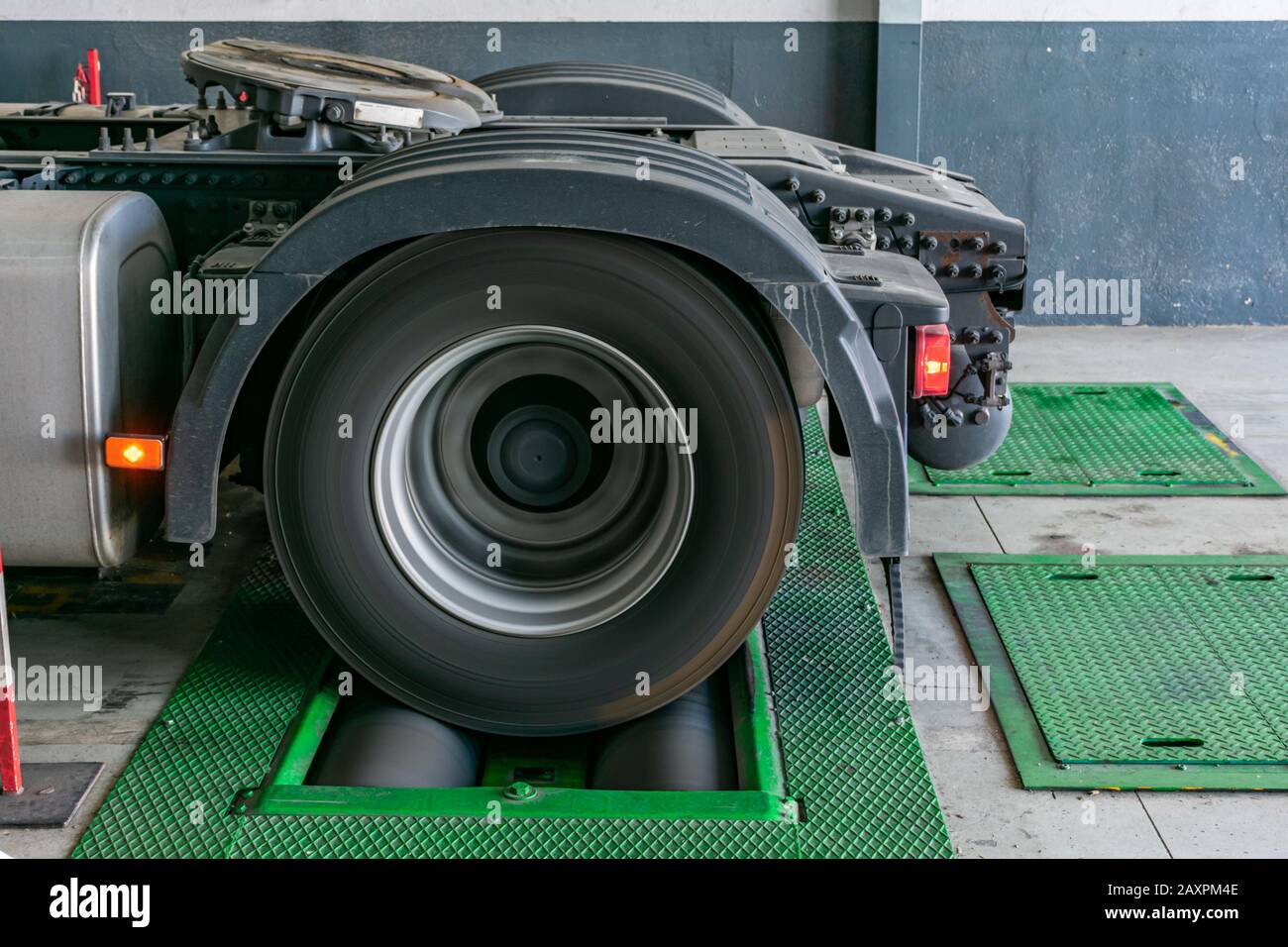 Truck wheel rotating on rollers to control the brakes and measure distances traveled by the tire for the vehicle's job registration device. Stock Photo